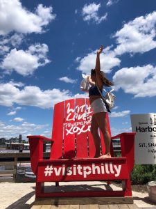 Anna Rago standing on a bright red chair in Philadelphia