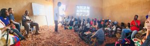 a crowd of adult learners gathered in a small building