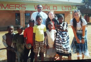 Ana Rago posing with children in Zowe and their families