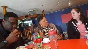 Bethany Hogan eating at a table with Pastor James and Pastor Christine